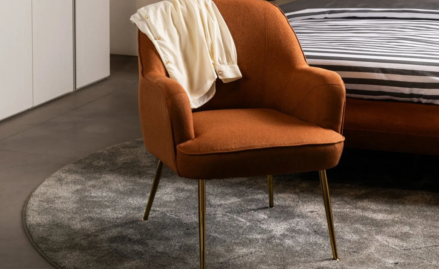 Marta poltrona in tessuto terra e gamba oro